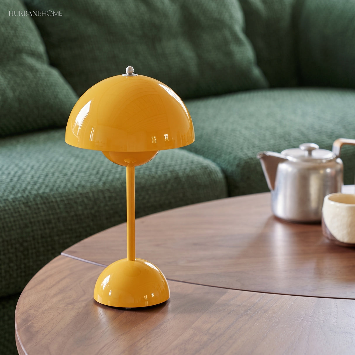 Yellow rechargeable table lamp on a round timber table with a teapot