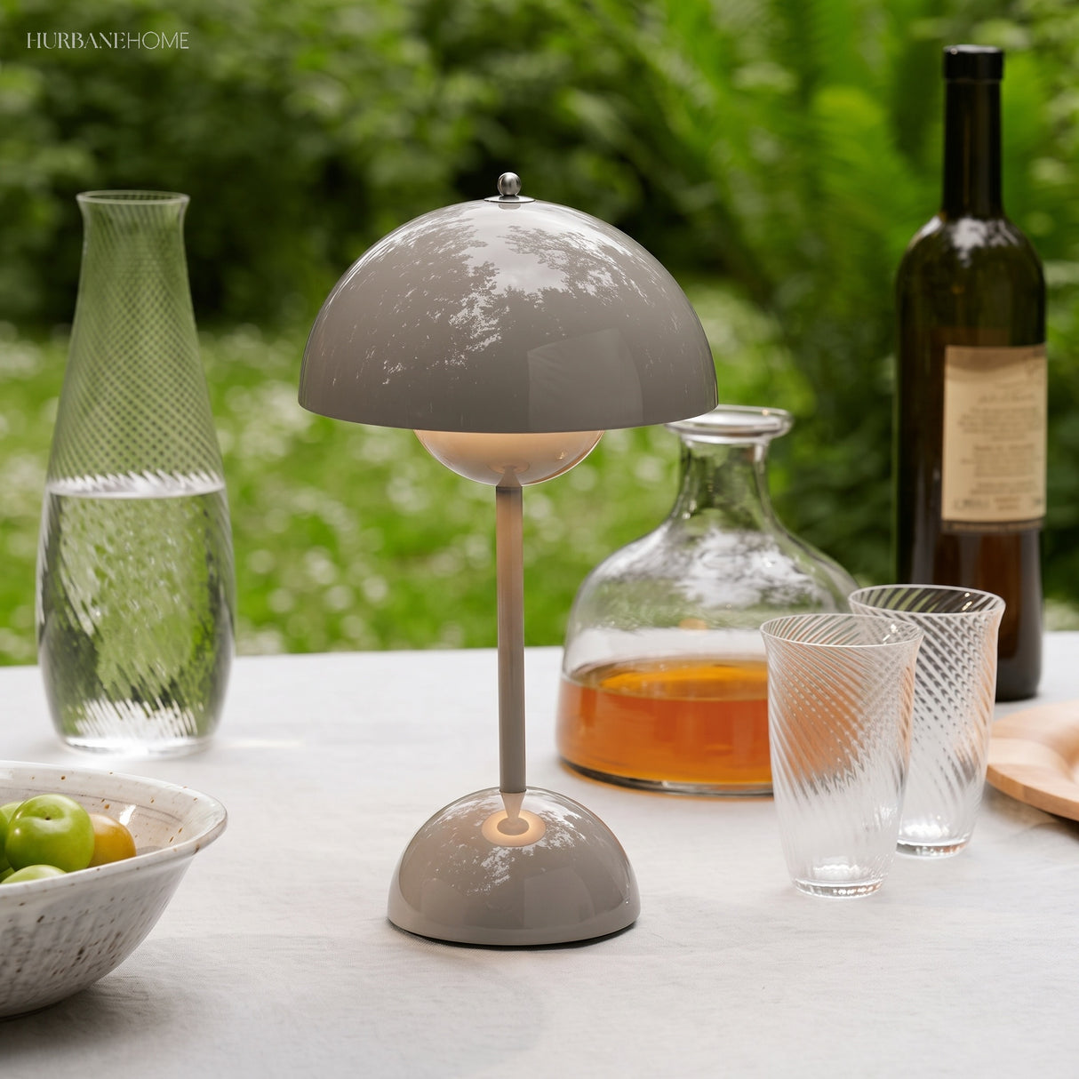Grey rechargeable table lamp on an outdoor table with glassware