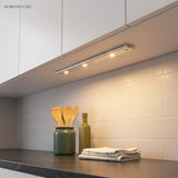 Light bar under white cabinets throwing an even wash across a timber counter