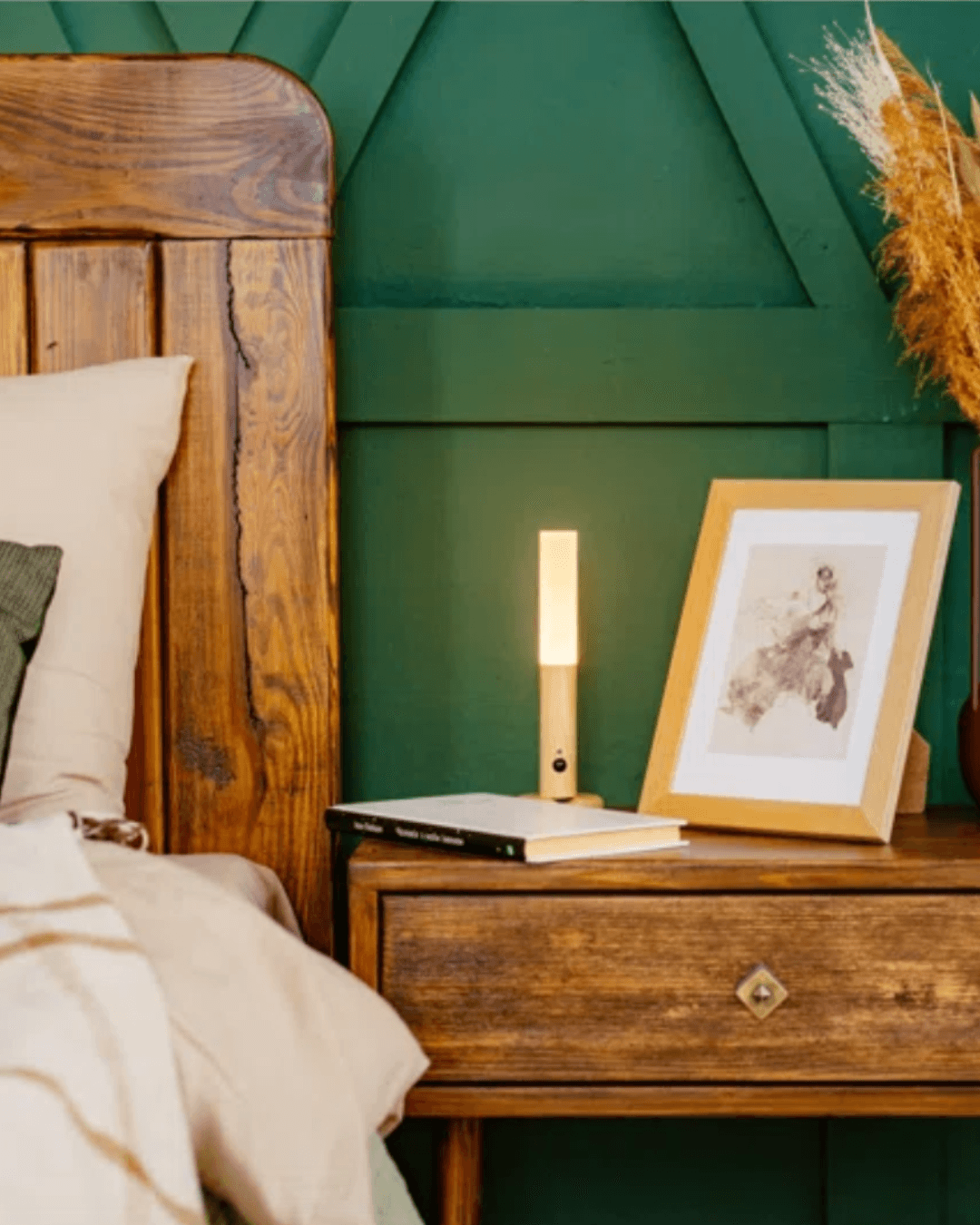 Warm sconce beside a bed with a carved wooden headboard and frame