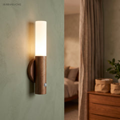 Warm lit sconce on a green bedroom wall beside an open doorway