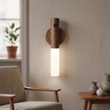 Wood topped rechargeable wall sconce lit beside an armchair and side table