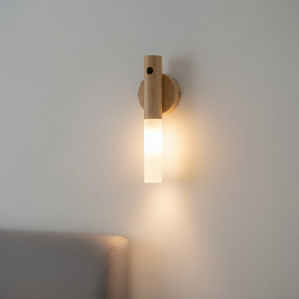 Light oak sconce lit on a pale wall above a grey sofa