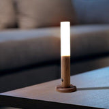 Light standing upright as a table lamp on a dark side table