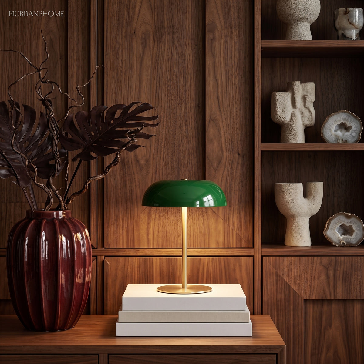 Green dome lamp on stacked books in front of walnut shelving