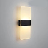 Black acrylic panel wall light lit on a plain grey wall