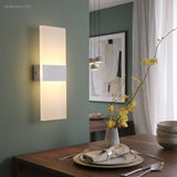 Acrylic panel wall light lit above a console table in a dining room
