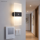 Acrylic panel wall light lit beside a doorway and light switch