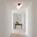 Red canopy globe light lit at the end of a plain white corridor