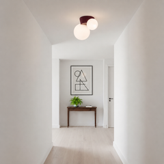 Red canopy globe light lit at the end of a plain white corridor