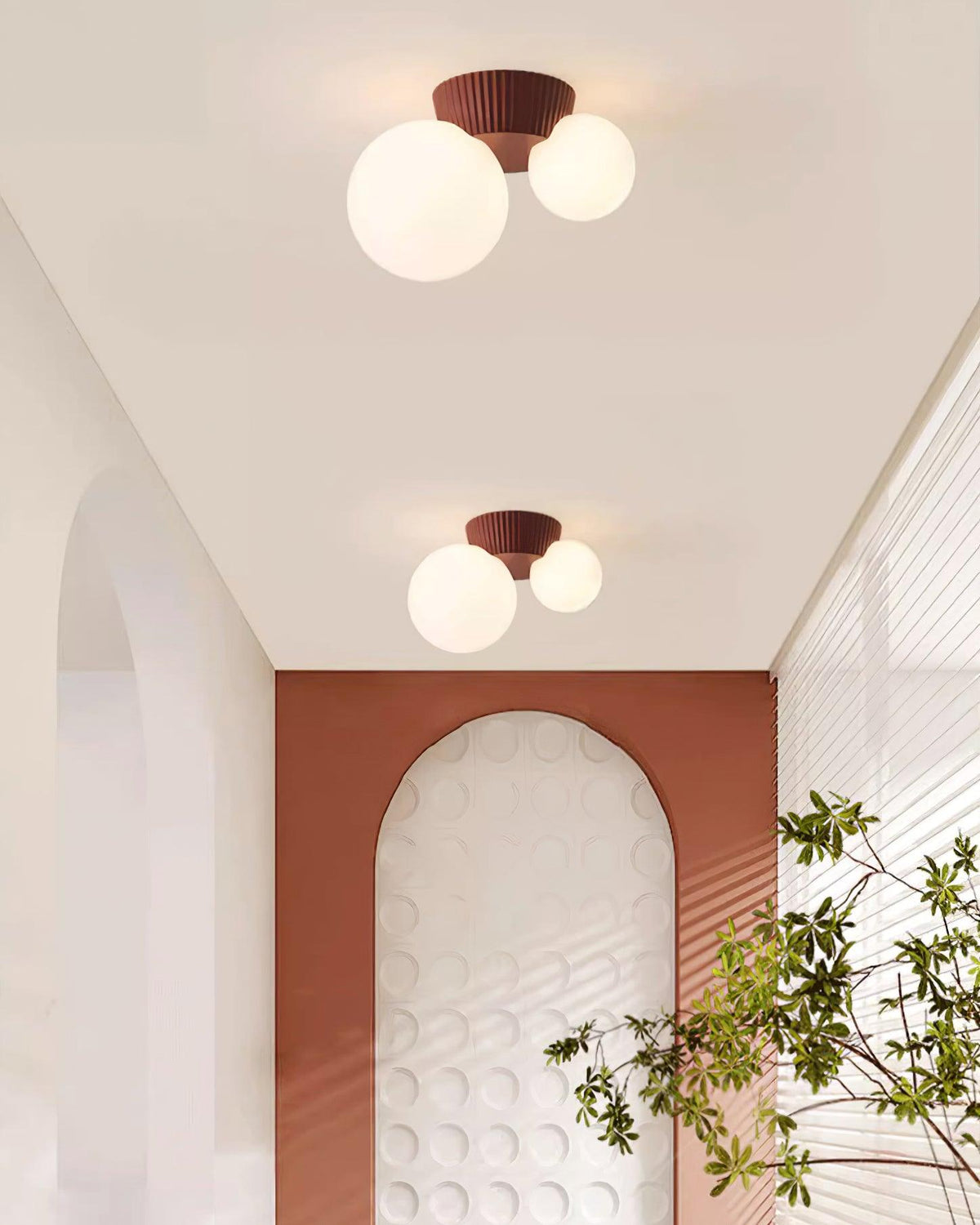 Red canopy globe lights above a terracotta arch with trailing greenery