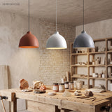 Terracotta, white and grey dome pendants over a rustic workshop bench