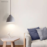 Grey speckled dome pendant above a side table beside a sofa