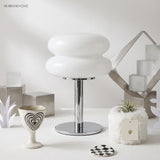 White glass table lamp on a styled desk with sculptural objects