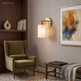 Brass ribbed glass wall light above a teak bench and abstract artwork