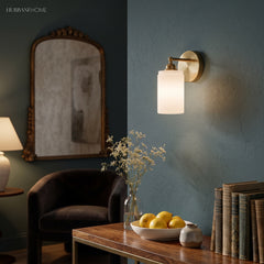 Brass ribbed glass sconce on a dark teal wall above a wooden table