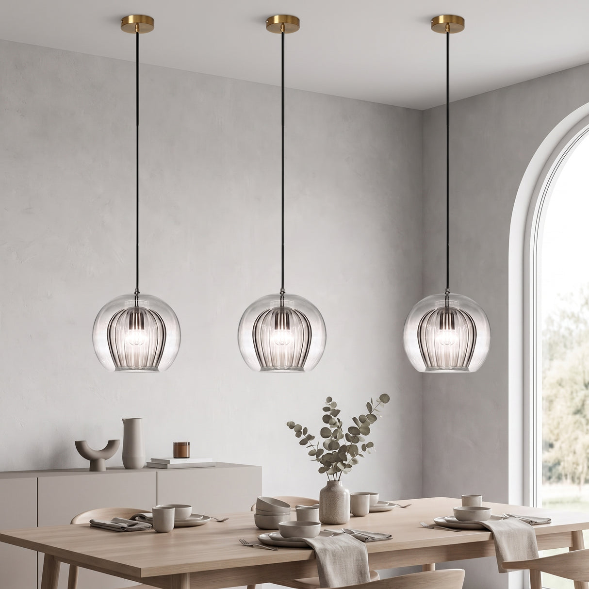Row of three ribbed glass globes with brass fittings over a long dining table