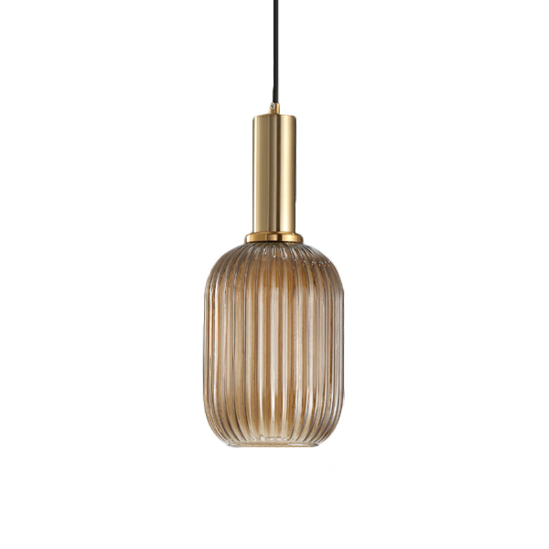 Amber ribbed capsule pendant with a brass collar on white