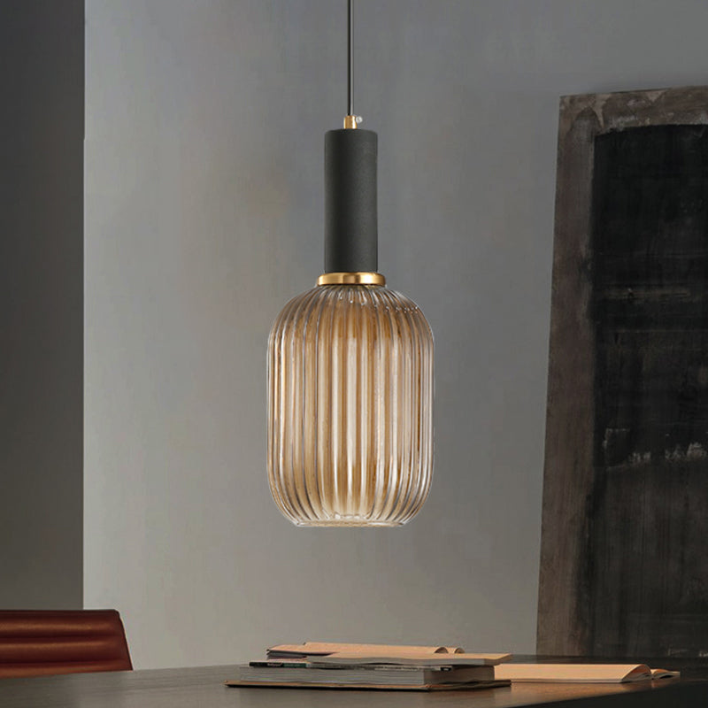 Amber ribbed pendant lit against a dark industrial brick wall