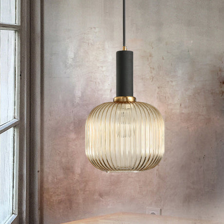 Amber ribbed pendant lit beside a window on a textured wall