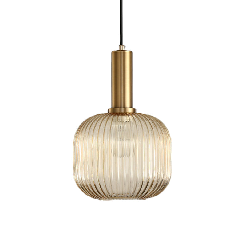 Amber ribbed cylinder pendant lit warm against a white backdrop
