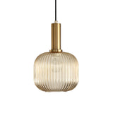 Amber ribbed cylinder pendant lit warm against a white backdrop