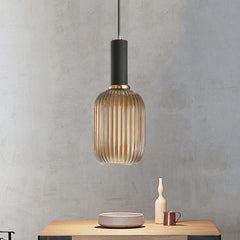 Amber ribbed pendant lit on a grey wall above a small table
