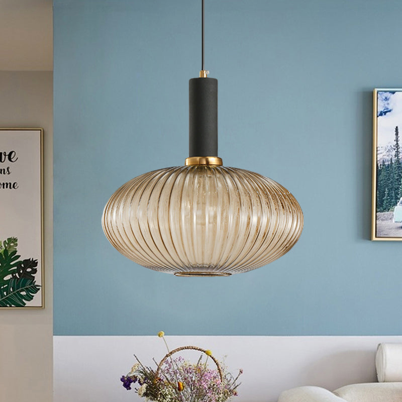 Amber ribbed oval pendant lit on a blue wall above a basket