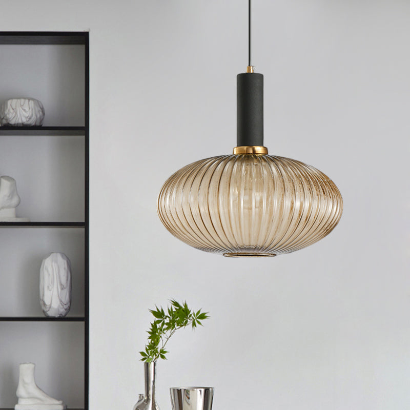 Amber ribbed oval pendant lit beside shelving holding vases