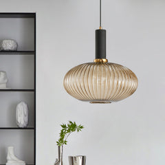 Amber ribbed oval pendant lit beside shelving holding vases