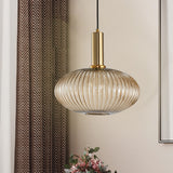 Amber ribbed oval pendant lit beside a curtain and cut flowers