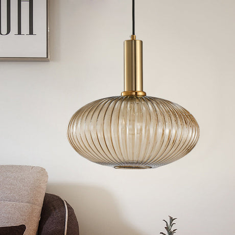 Amber ribbed oval pendant lit on a pale wall behind a sofa