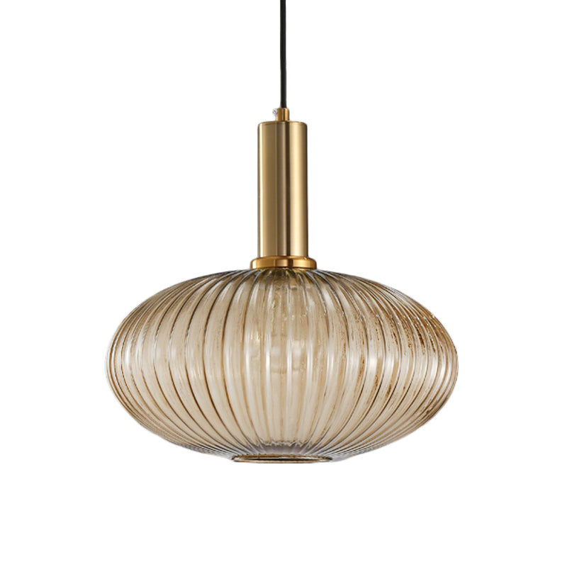 Amber ribbed oval pendant with a brass collar, shown on white