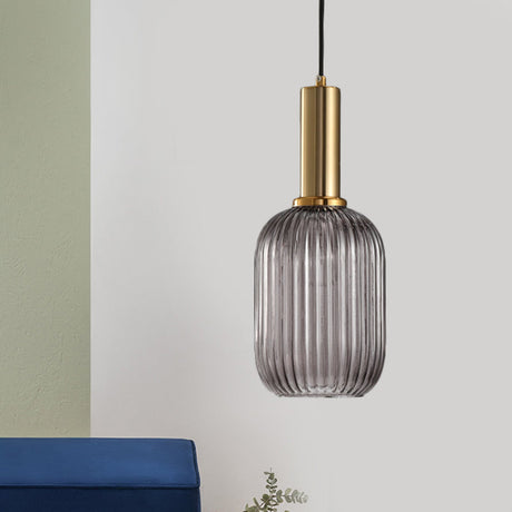 Green ribbed capsule pendant lit on a green wall by a blue chair