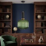 Green ribbed pendant lit in a navy study lined with bookshelves
