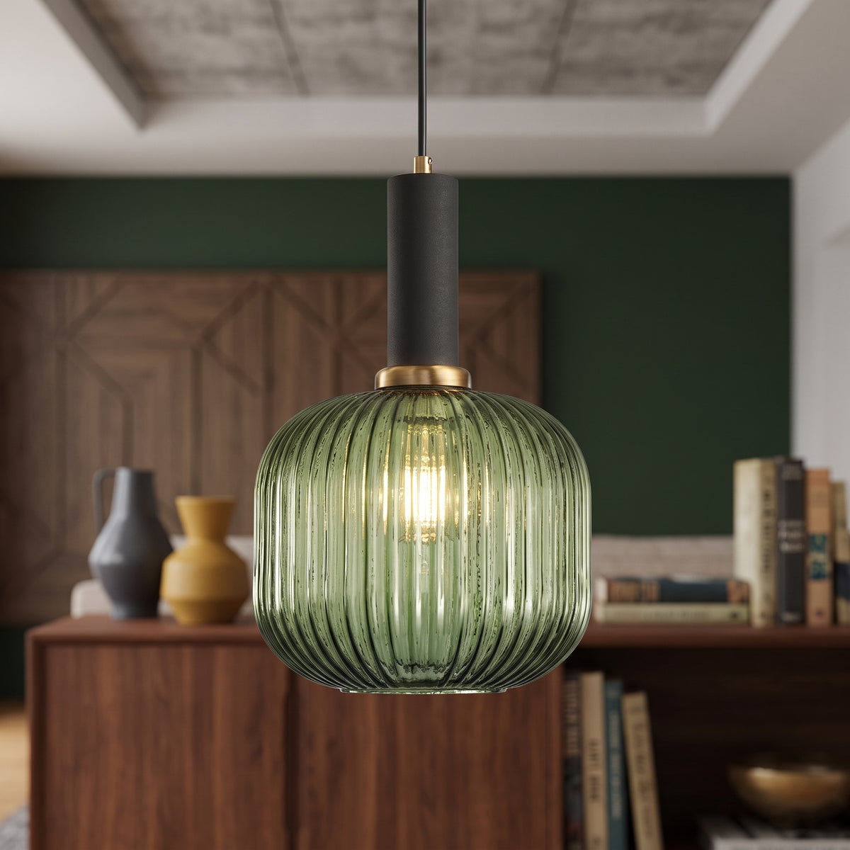 Green ribbed glass pendant lit above a sideboard on a green wall