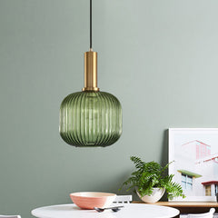 Green ribbed pendant lit above a table set with bowls and plants
