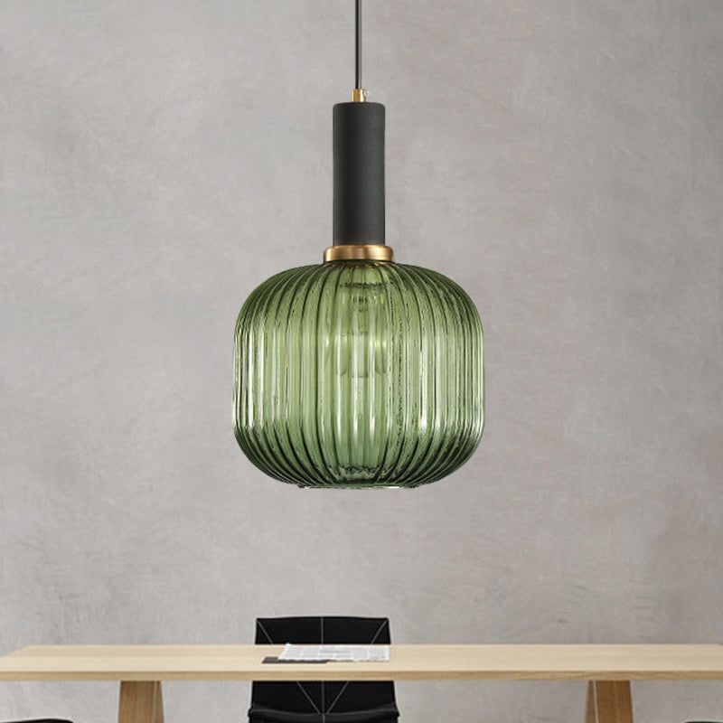 Green ribbed pendant lit against a concrete wall above a table