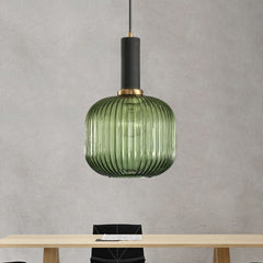 Green ribbed pendant lit against a concrete wall above a table
