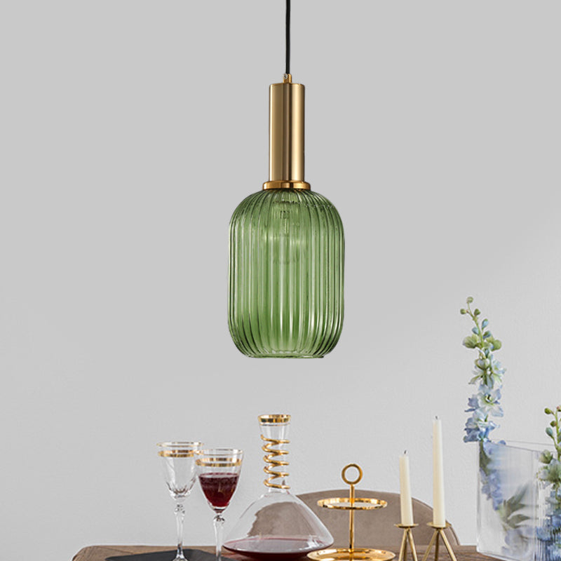 Green ribbed pendant lit above a table laid with glassware