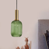 Green ribbed pendant lit on a pink wall above small figurines