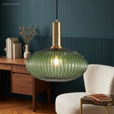 Green ribbed oval pendant lit beside a fluted teal wall panel