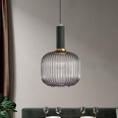 Smoke ribbed pendant lit above a dining table by a green sofa