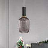 Smoke ribbed pendant lit on a white wall beside a Christmas tree
