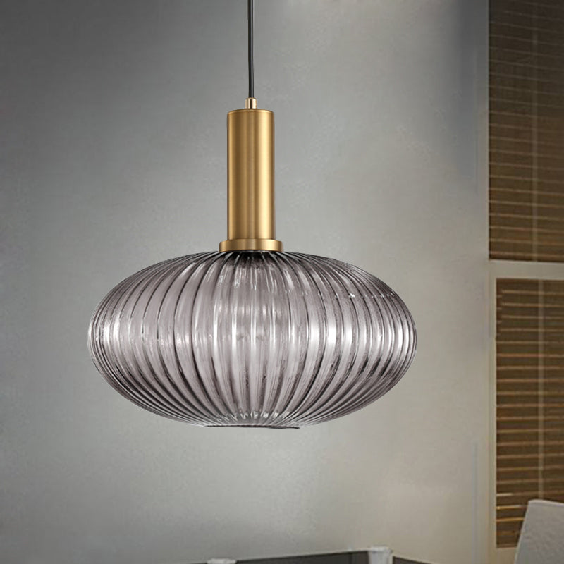 Smoke ribbed oval pendant lit against a plain grey backdrop