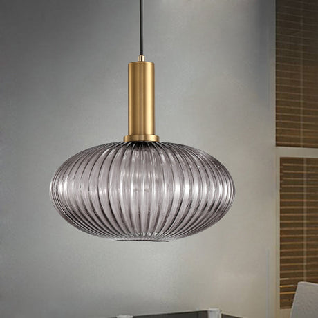 Smoke ribbed oval pendant lit against a plain grey backdrop