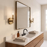 Two brass ribbed glass tube sconces flanking a bathroom vanity mirror