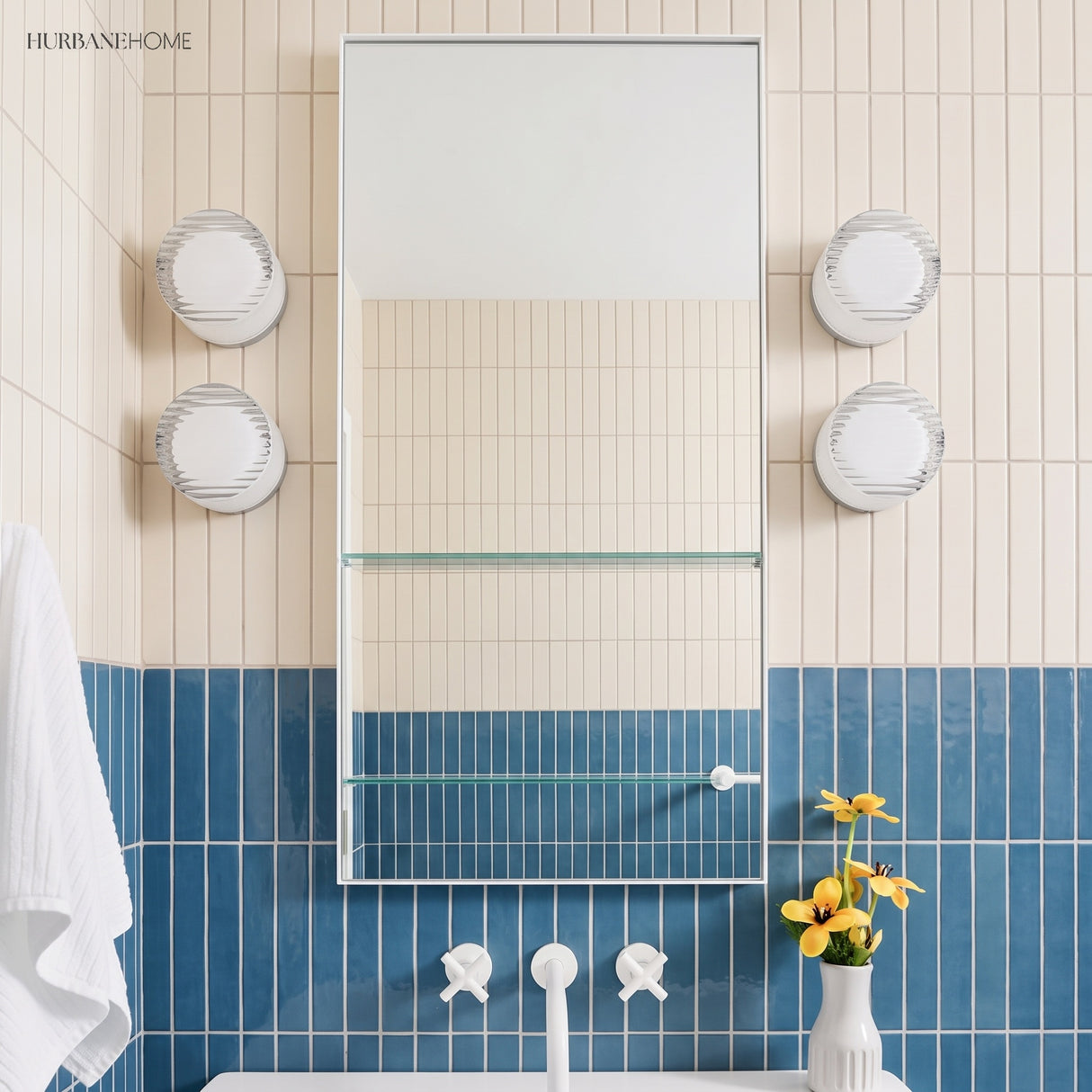 Four ribbed wall lights flanking a bathroom mirror above blue tiles