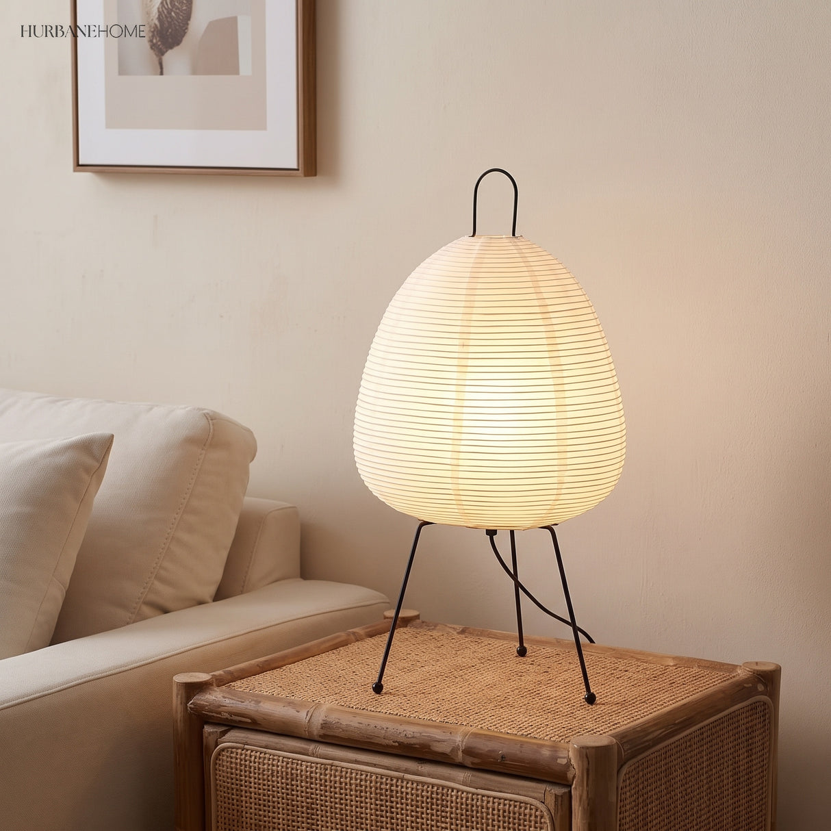 Rice paper table lamp on a rattan side table beside a linen sofa