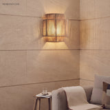 Rope wall lamp on a stone wall above a sofa and side table